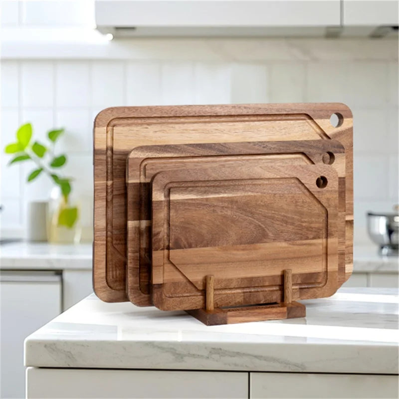 Set of 3 acacia wooden cutting boards with a holder on a kitchen counter