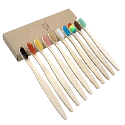Set of bamboo toothbrushes with colored bristles on a white background
