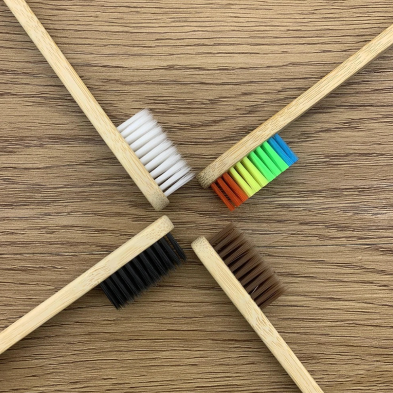 Five wooden brushes with different colored bristle patterns on a wooden surface