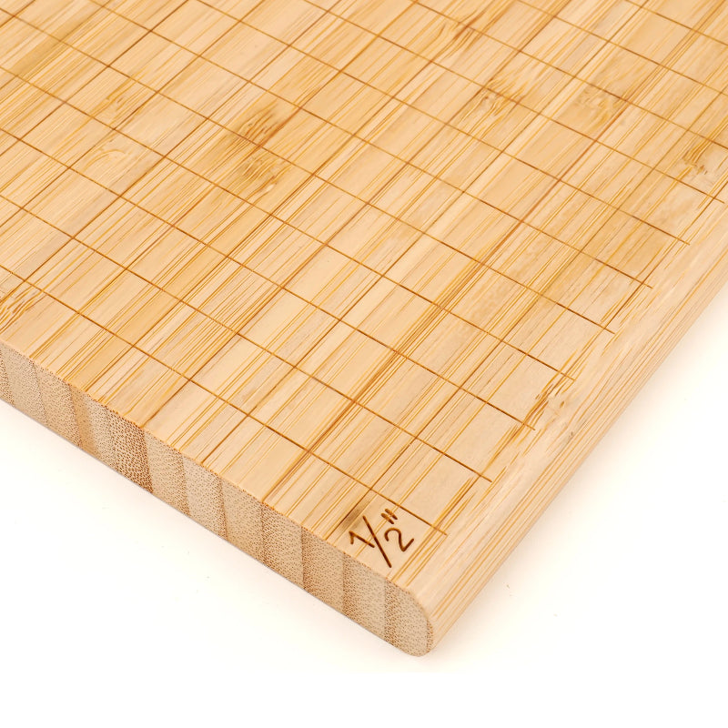 Bamboo cheese cutting board with grid pattern and measurement marking on a white background