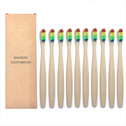 Set of bamboo toothbrushes with rainbow bristles next to a cardboard box labeled 'Bamboo Toothbrush'.