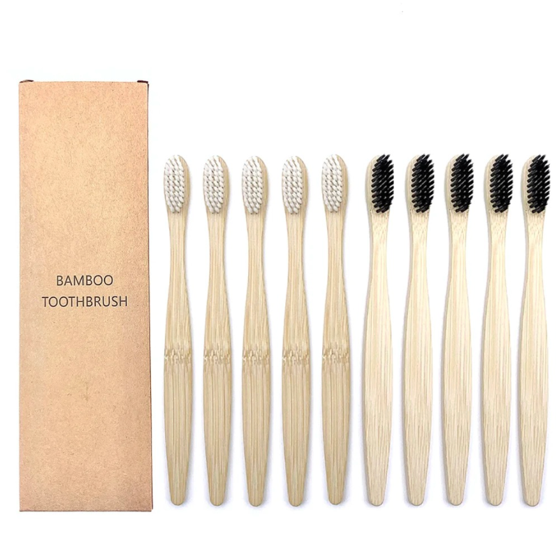 Set of bamboo toothbrushes with black a bristles and white bristles and a cardboard box on a white background