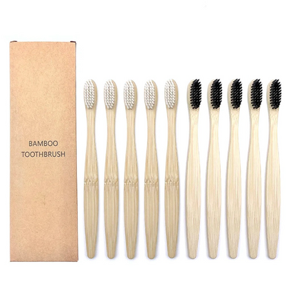 Set of bamboo toothbrushes with black a bristles and white bristles and a cardboard box on a white background