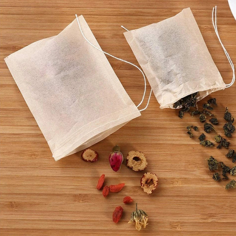biodegradable Tea bags on a wooden surface with dried herbs and leaves on a wooden surface.