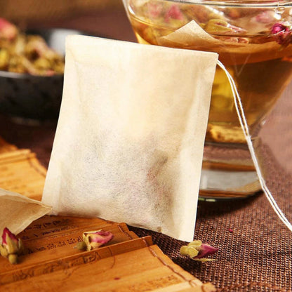 Close up of a natural drawstring tea bag showing the biodegradable paper texture and the cotton string.