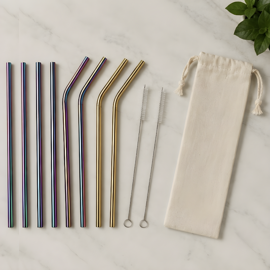 Eight reusable stainless steel straws in gold and rainbow, two cleaning brushes and one eco-linen carry pouch laid flat on marble surface, complete plastic-free metal straw kit.